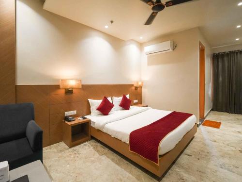 a hotel room with a bed with red pillows at Lemonade Hotel Alwar in Alwar