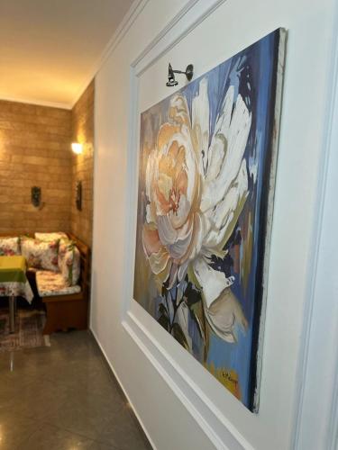 a painting of a flower on a wall in a room at Iceland Apartment in Tirana