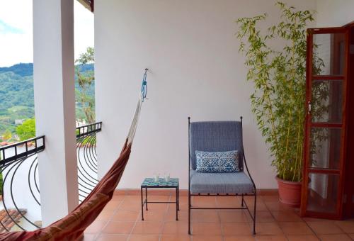 a room with a hammock and a chair on a balcony at Terramaya Boutique Hotel in Copan Ruinas