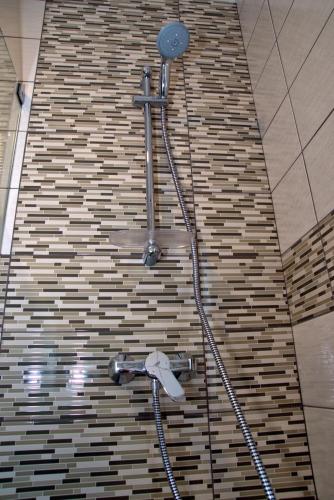 a shower in a bathroom with a brick wall at Tonel Apartamentos Turisticos in Sagres