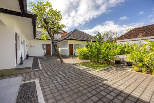 a courtyard of a house with a tree at Cove Dahayu Sanctuary in Sanur