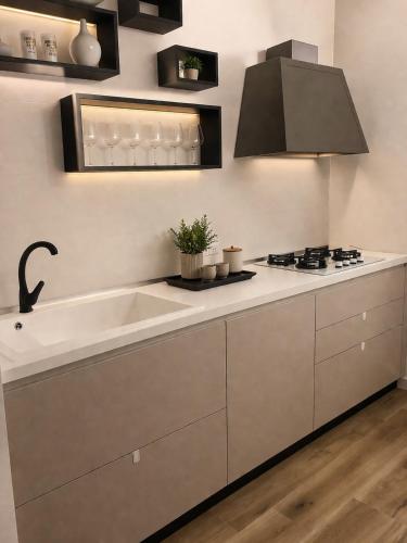 a kitchen with a sink and a stove at A Due Passi Dalla Scalinata Rooms in Caltagirone