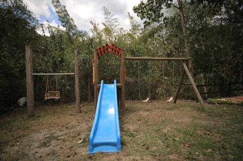 a playground with a blue slide in a yard at HOTEL LA SELVA Reserva in La Vega