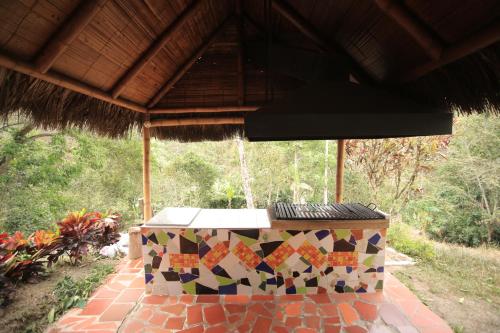 a table with a mosaic pattern on it under a roof at HOTEL LA SELVA Reserva in La Vega