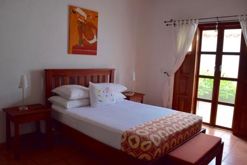 a bedroom with a bed with white sheets and pillows at Terramaya Boutique Hotel in Copan Ruinas