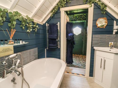 a bath tub in a bathroom with blue walls at Applejacks Orchard in Holywell