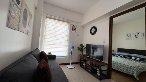 a living room with a couch and a television at Peppers Crib in Manila