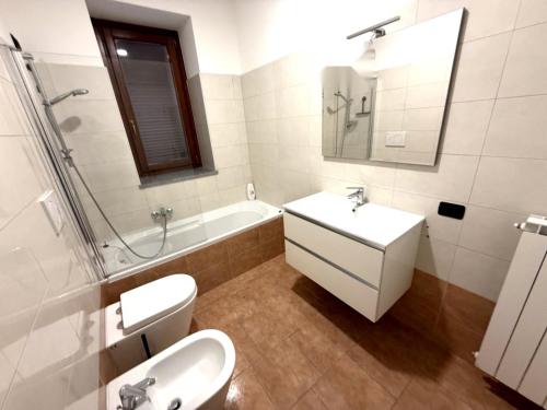 a bathroom with a sink and a toilet and a tub at Casa ajolote in Cunardo