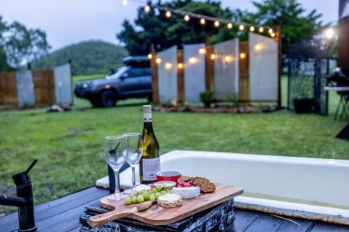 a bottle of wine and wine glasses on a table at Echidna by Tiny Away in Thoopara