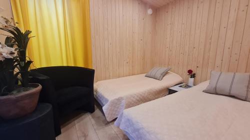 a room with two beds and a chair and a plant at Jomas & Baltic beach in Jūrmala