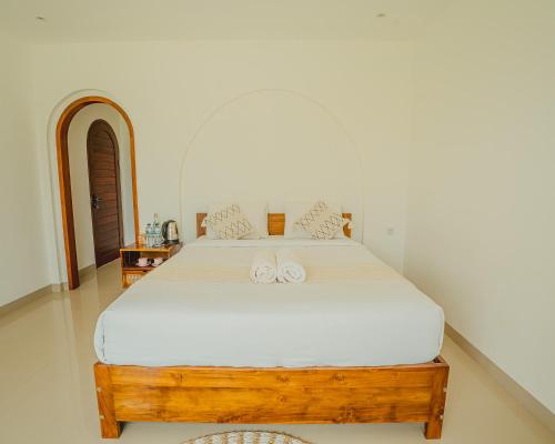 a bedroom with a bed with two white towels on it at Star Hill Kintamani in Kubupenlokan