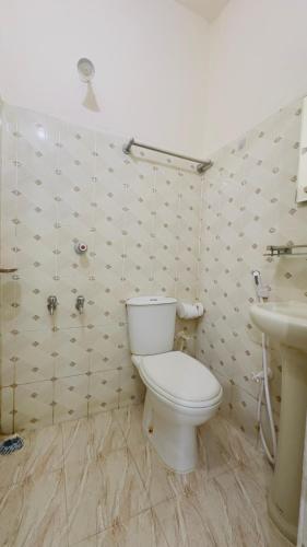 a bathroom with a toilet and a sink at Hotel Labbaik Three College Gate in Dhaka