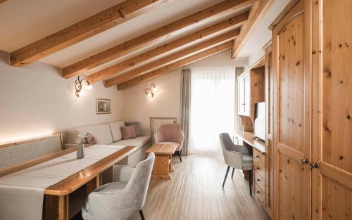 a kitchen and living room with a table and chairs at Appartementhaus Residence Hirzer in Tirolo