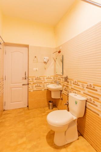 a bathroom with a toilet and a sink at Riyan Valley Resort in Ooty