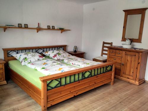a bedroom with a wooden bed and a wooden dresser at Landhaus Grimburg - Ferienwohnungen im Parterre und Obergeschoss in Grimburg