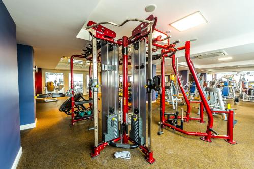 a gym with several treadmills and machines at Jumbaktas Astana Hotel in Astana
