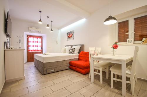 a bedroom with a bed and a table and a dining room at Luxury Apartments Luka & Marko in Cavtat