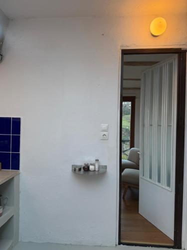 a room with a white wall with a door and a chair at Apple Orchard Pelion in Volos