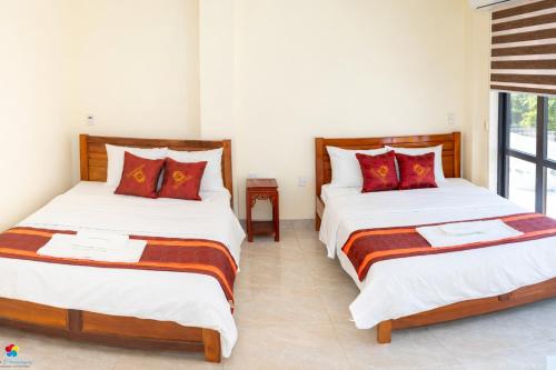 two beds in a room with white walls at Việt Hà Motel in Bảo Lạc