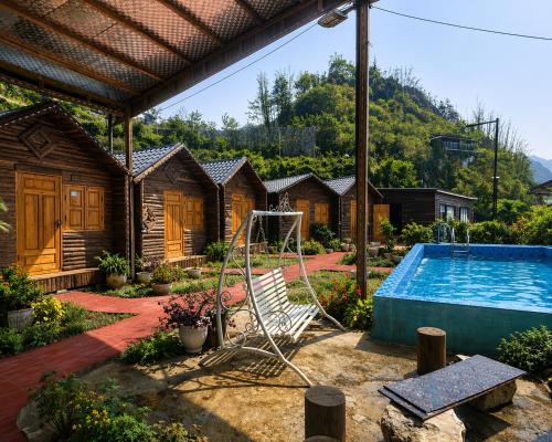 a swimming pool in a yard with a group of houses at Sapa May Ecolodge in Sapa