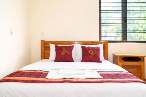 a bedroom with a bed with red pillows at Việt Hà Motel in Bảo Lạc