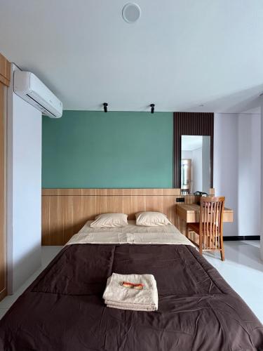 a bedroom with a bed with a towel on it at Pangeran Residence 2 in Adi Sutjipto