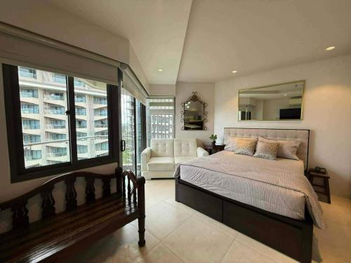 a bedroom with a bed and a couch and a mirror at stevenplace at Tambuli in Maribago