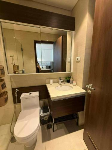 a bathroom with a toilet and a sink and a mirror at stevenplace at Tambuli in Maribago
