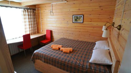 ein Schlafzimmer mit einem Bett mit zwei orangenen Kissen darauf in der Unterkunft Baza Otdykha Chara in Sarma