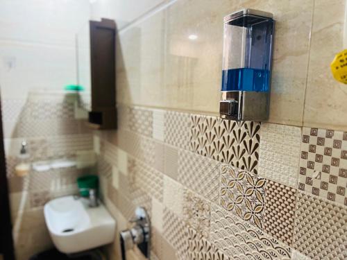 a tiled bathroom with a toilet and a sink at Palm Suite With Sky Terrace Penthouse 11th Floor in Rajkot