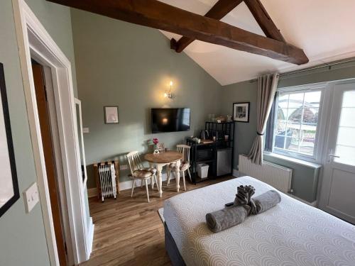 a bedroom with a bed and a dining room with a table at Hollyside Lodge in Carlisle
