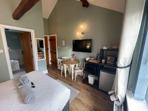 a bedroom with a bed and a table and a television at Hollyside Lodge in Carlisle