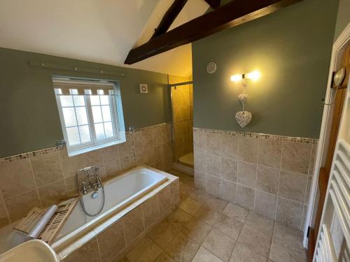 a bathroom with a bath tub and a window at Hollyside Lodge in Carlisle