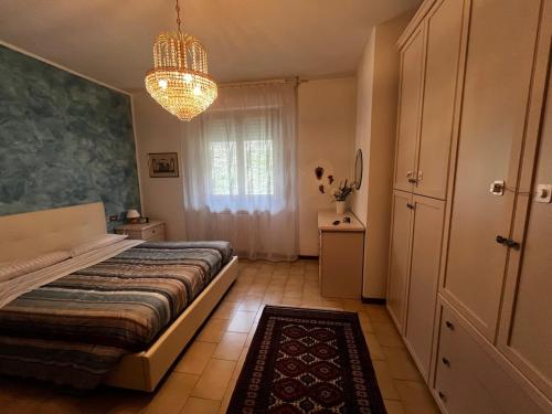 a bedroom with a bed and a chandelier at Casa di Azzurra in Capolona