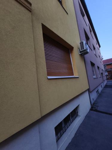 a building with a window with a blind on it at Toldi 5 Apartman in Pécs