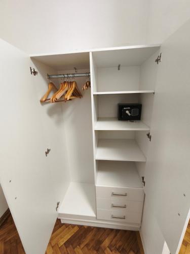 a walk in closet with white walls and shelves at Toldi 5 Apartman in Pécs