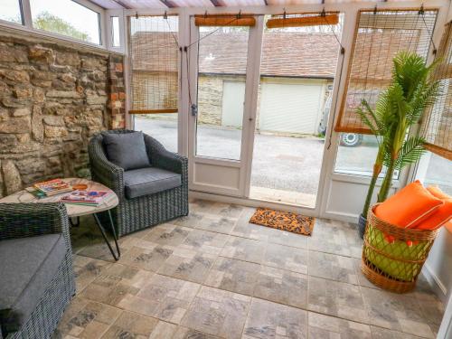 a conservatory with a chair and a table at Long Barn in Bridport
