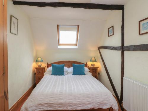 a bedroom with a wooden bed with blue pillows at The Stables in Sturminster Newton