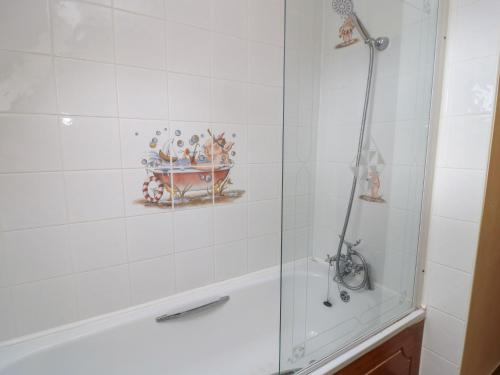 a bathroom with a shower and a bath tub at The Stables in Sturminster Newton