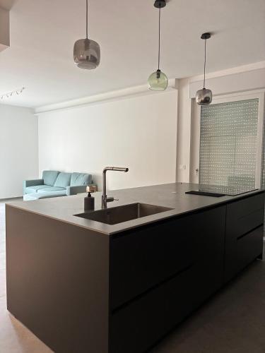 a black kitchen with a sink and a couch at Biancamilla's Home in Giulianova