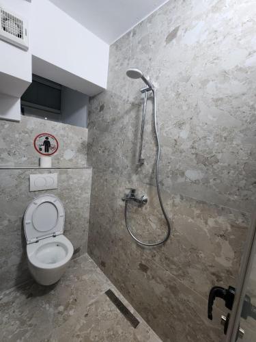 a bathroom with a shower and a toilet at The HANGOUT Hostel in Sarandë