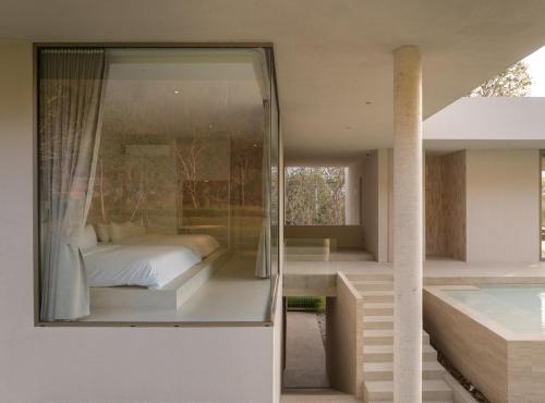 a glass house with a bed and a balcony at Number Three Pool Villa Khaoyai in Ban Tha Maprang