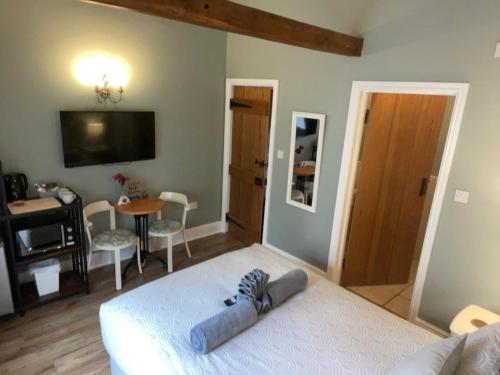 a bedroom with a bed and a dining room with a table at Hollyside Lodge in Carlisle
