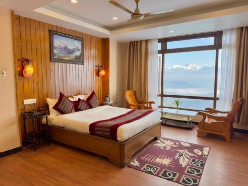 a bedroom with a bed and a large window at The Garden Courtyard in Kalimpong