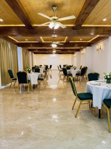 a banquet hall with tables and chairs and a ceiling at The Garden Courtyard in Kalimpong