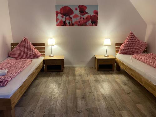 two beds in a room with two tables and two lamps at Ferienhof von Hammel in Sevelten
