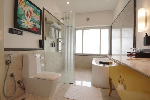 a bathroom with a toilet and a sink and a tub at Mayfair Waves in Puri