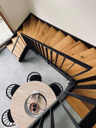 a wooden spiral staircase with a wooden table at Ferienhaus MOSELLODGE in Enkirch