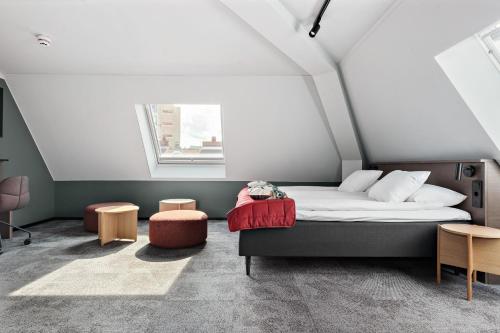 a bedroom with a bed and two tables and a window at Best Western Hotel Esplanade in Västerås
