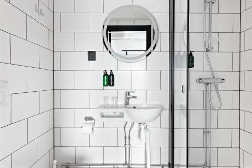 a bathroom with a shower and a sink and a mirror at Best Western Hotel Esplanade in Västerås